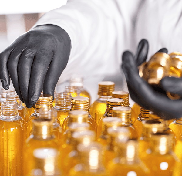 Perfume bottles being prepared with golden oils